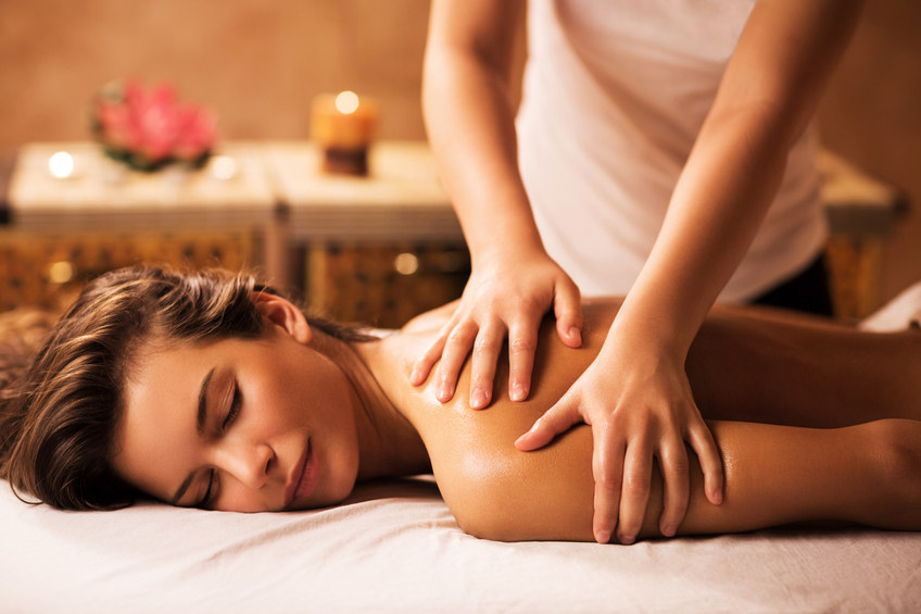 Massaging in the spa. Young woman enjoying in back massage at the spa.